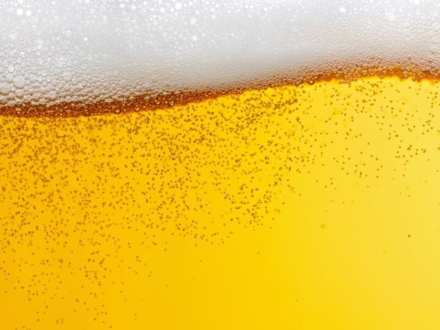 Golden beer with a frothy white head and visible bubbles.